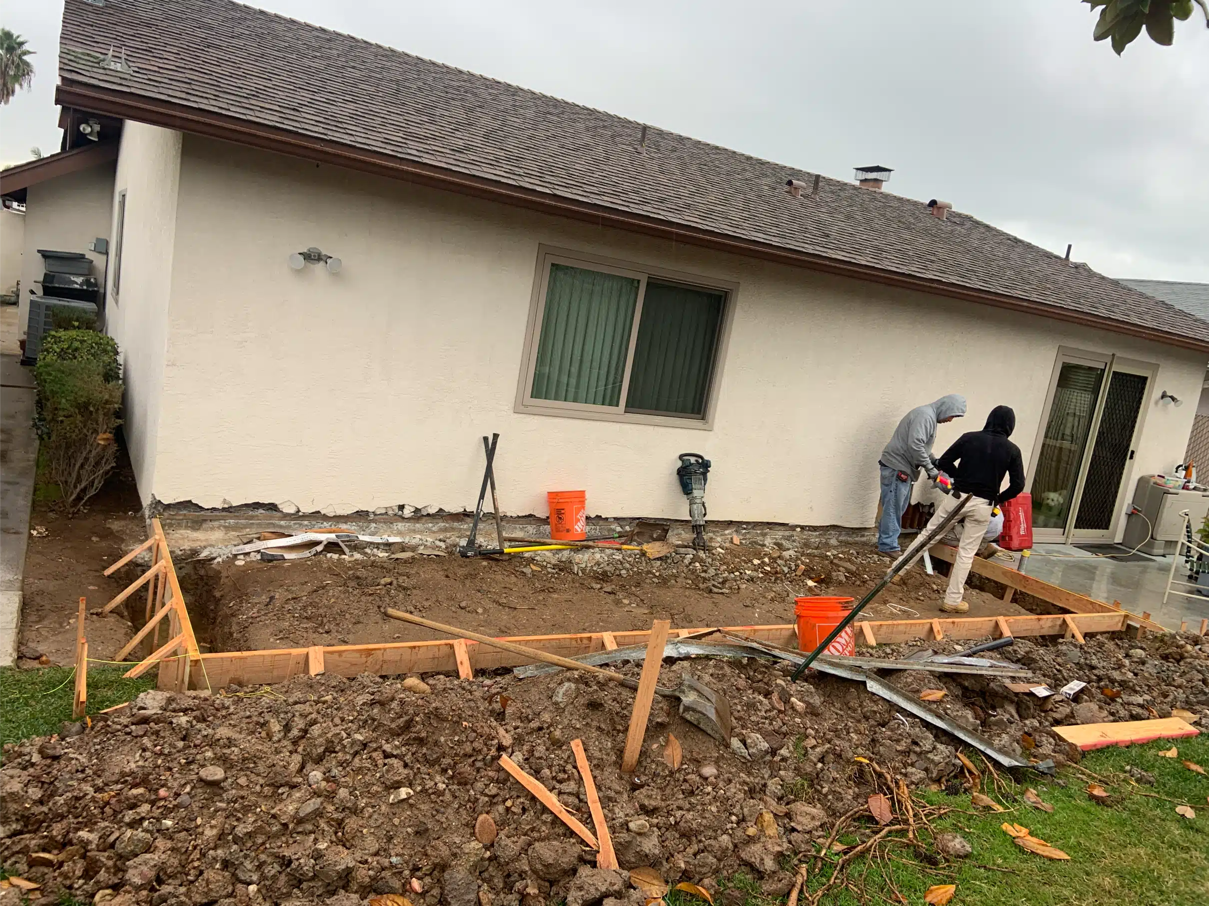 Trenching and forms set out for the new foundation alongside the existing house