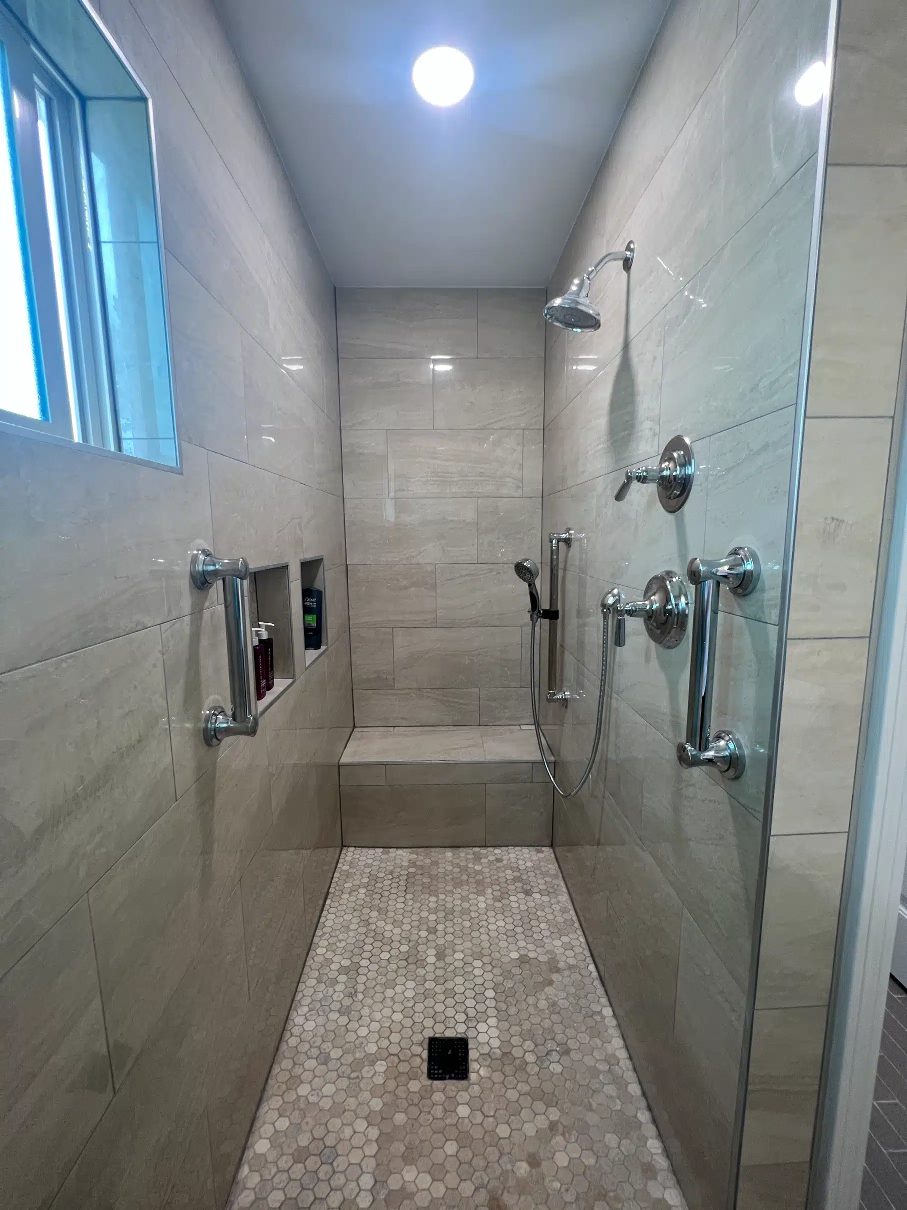 Accessible walk-in shower with grab bars and a bench, built as part of a San Diego room addition