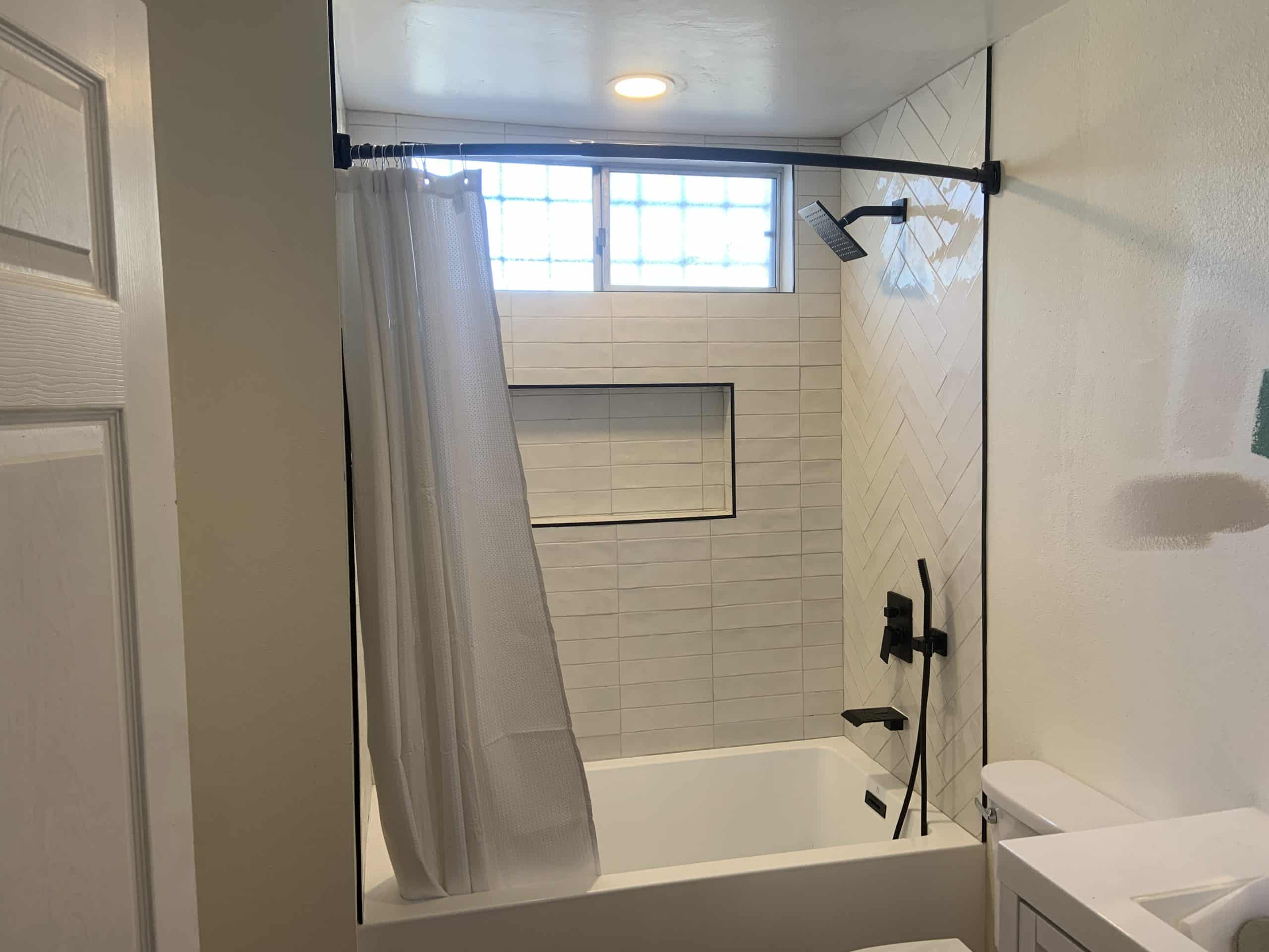 New tub and curtain rod in place of the original framed sliding doors