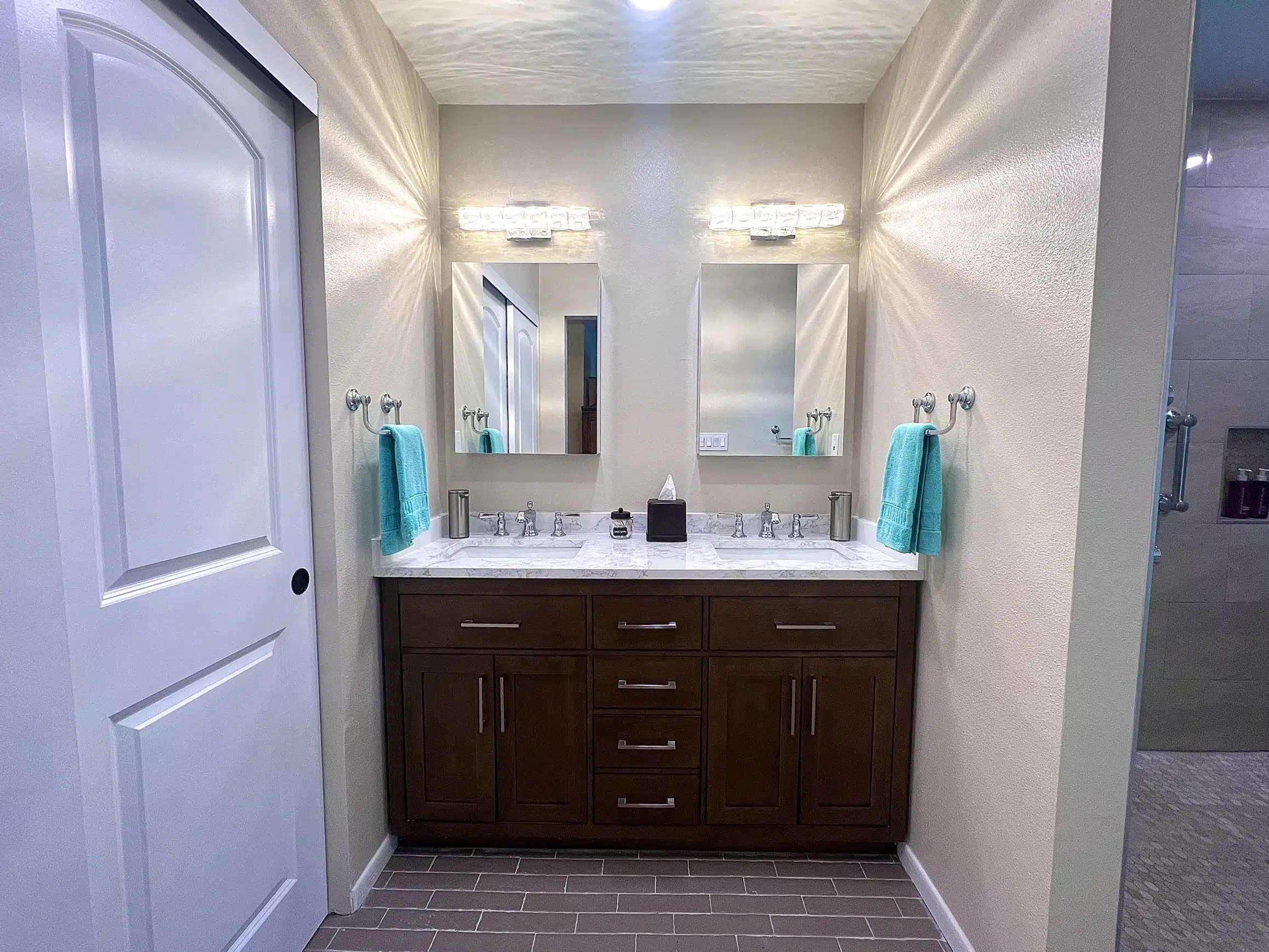 Double vanity in dark timber with a wall-hung mirror in the new bathroom
