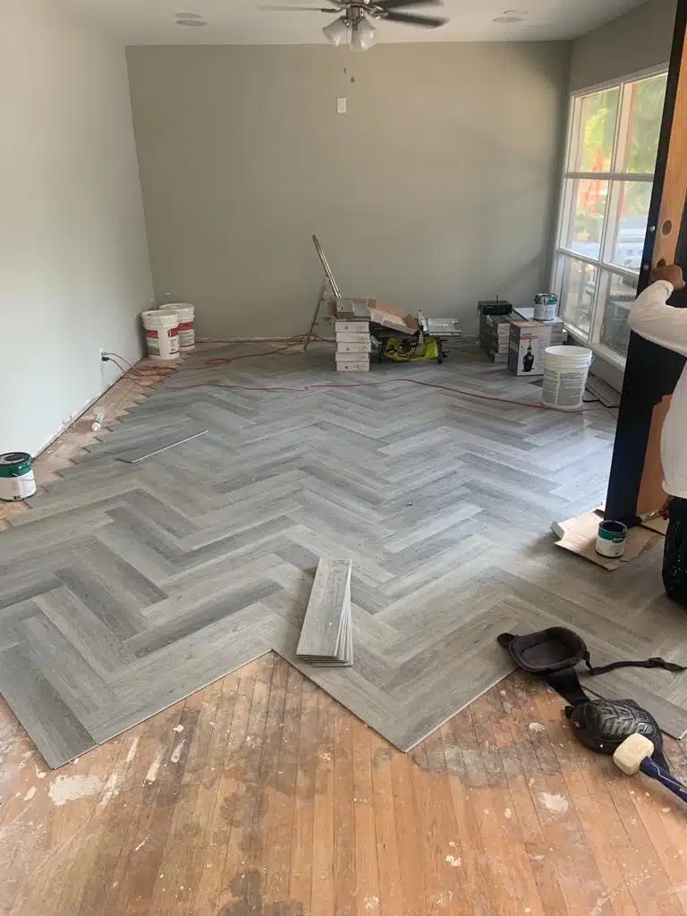 Herringbone plank flooring being laid over the original floor in the Del Mar home