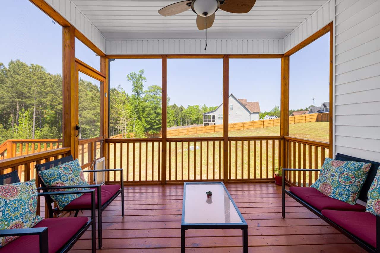 Covered addition with a timber ceiling and railing opening onto the rear yard