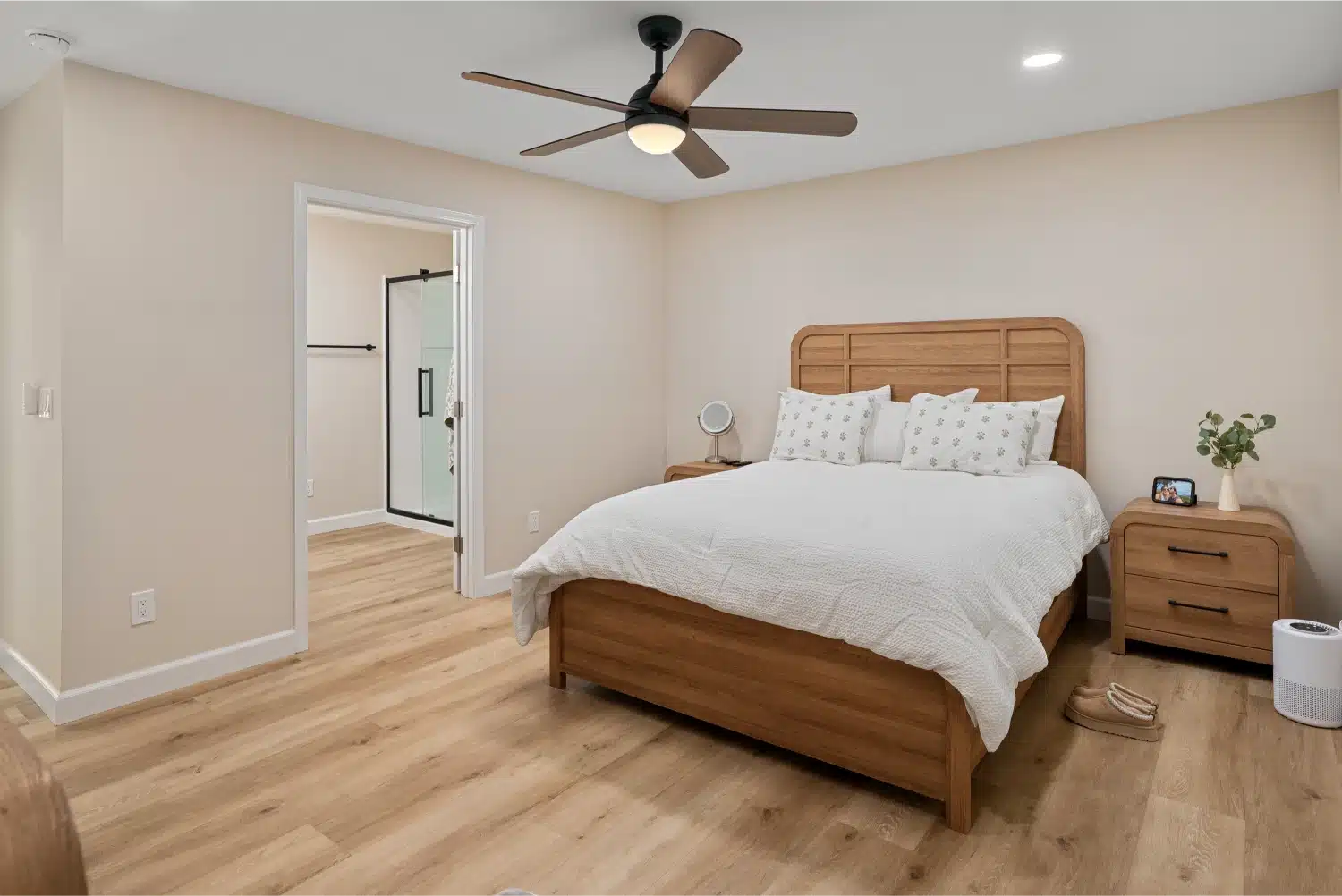 Bedroom with an oak bed frame, ceiling fan and wood-look flooring