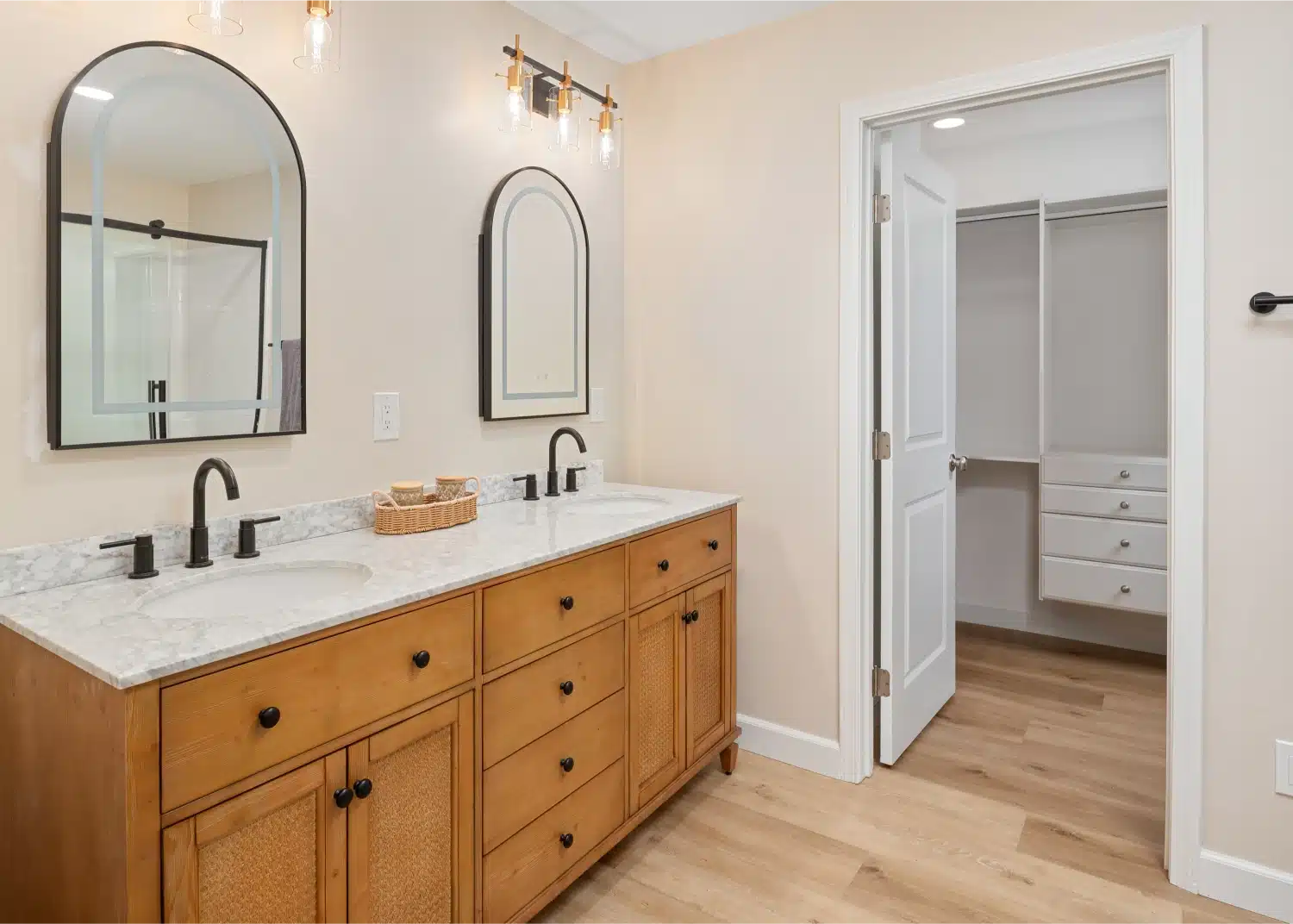 Oak vanity beside the open door to a fitted walk-in closet