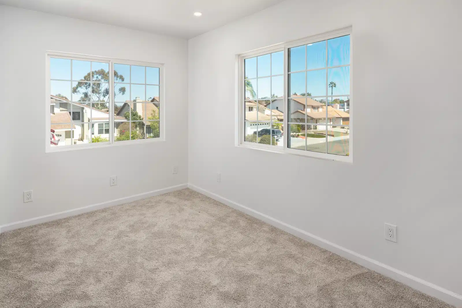 Carpeted room in the addition with two windows and natural light