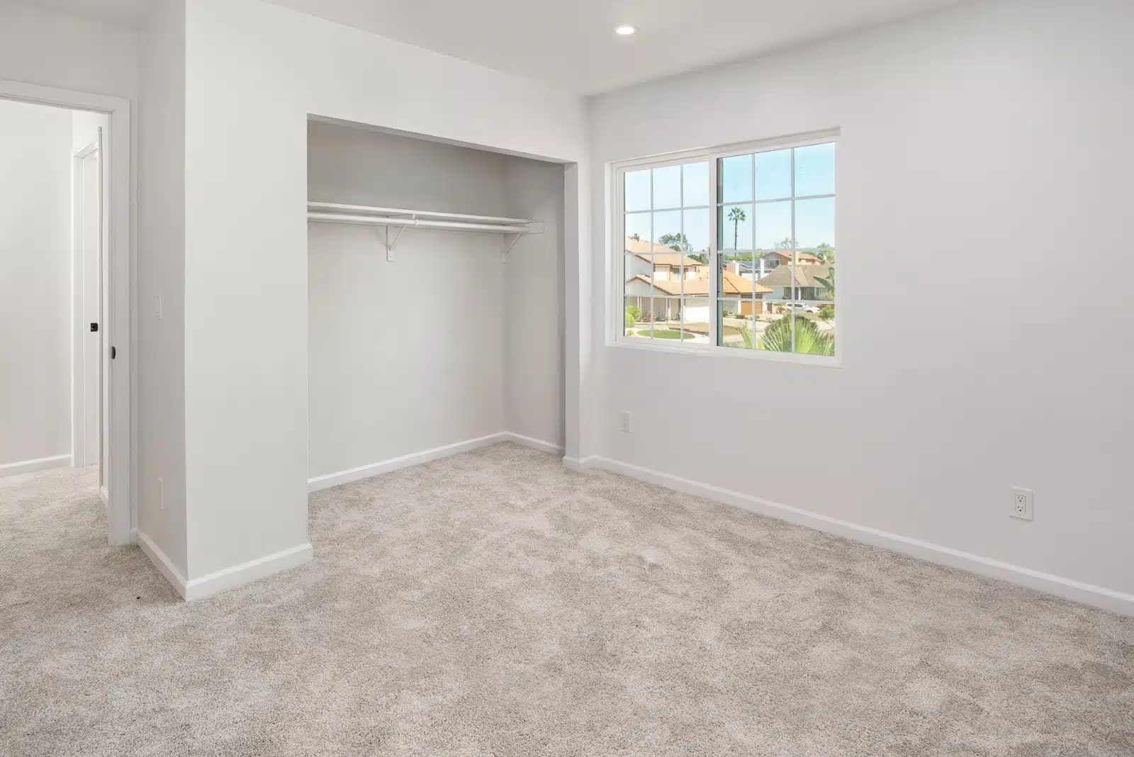 Carpeted room with a built-in closet and a window