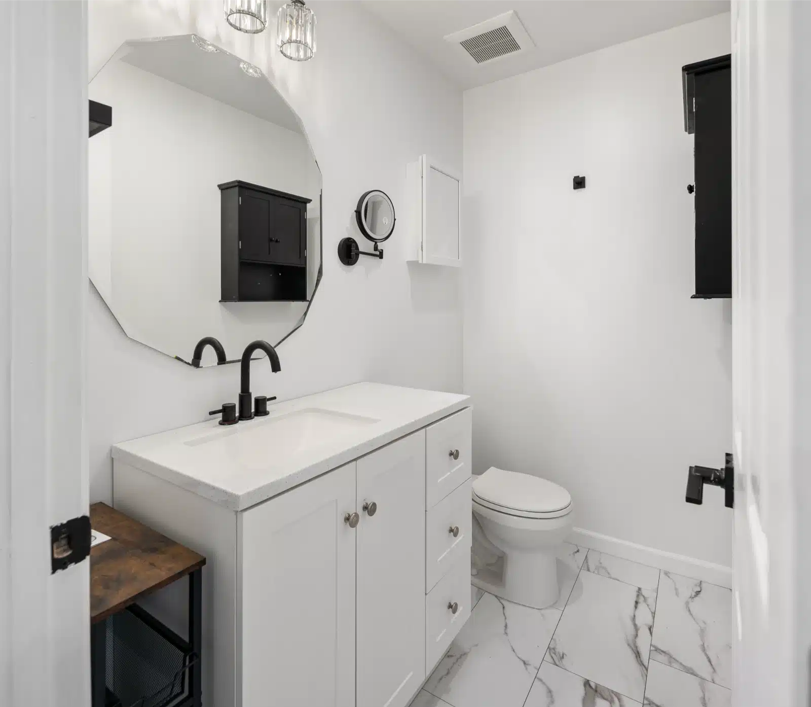 Second bathroom with a white vanity, oval mirror and marble-look tile floor