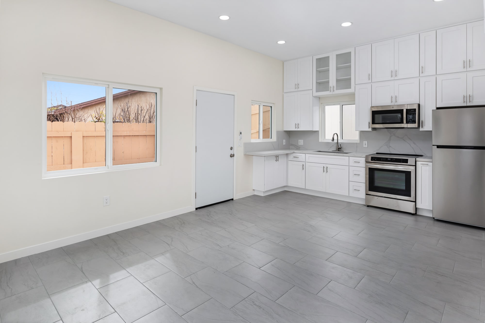 ADU kitchen and living space with tile flooring and a window to the yard