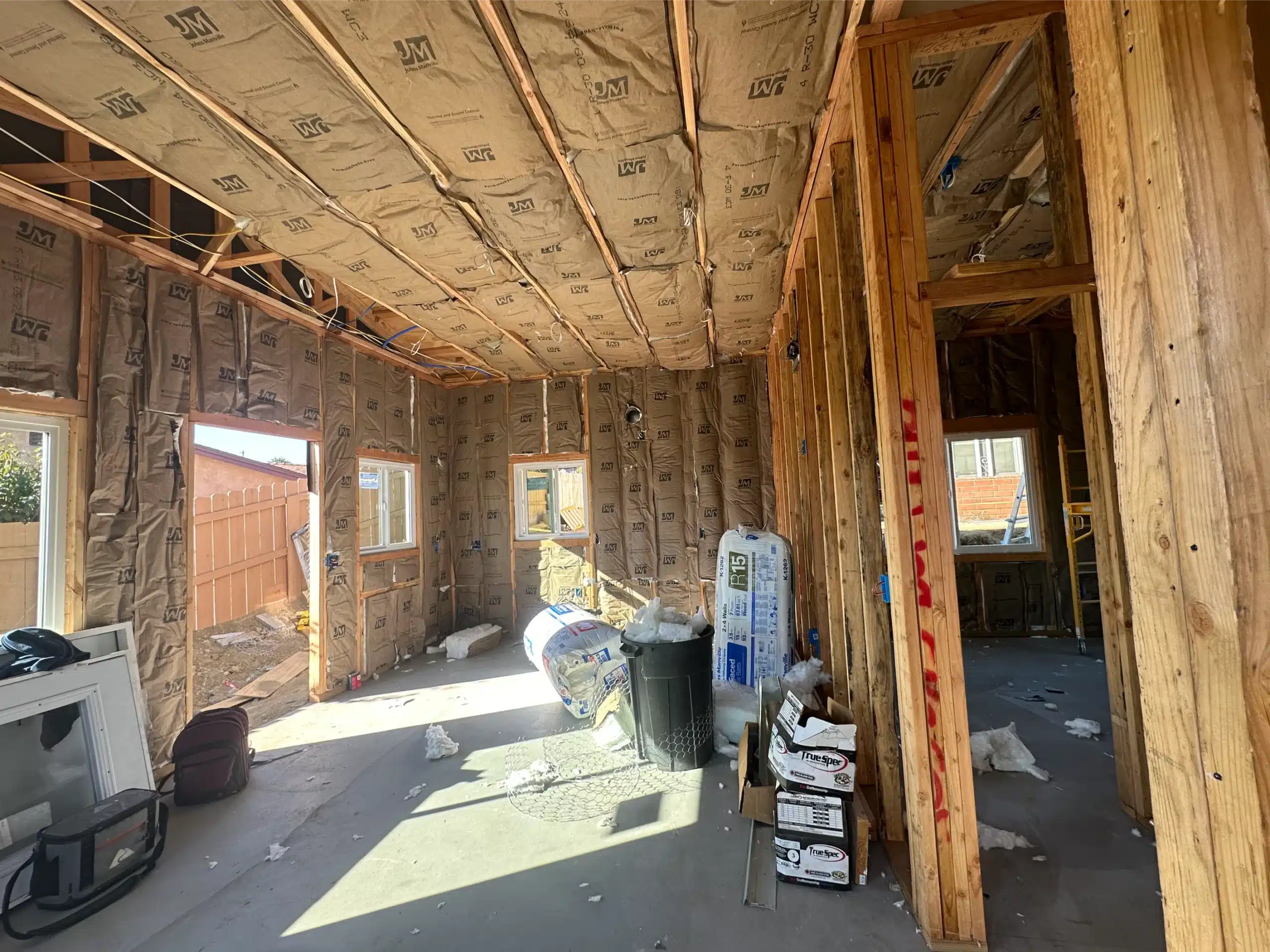 ADU interior with insulation installed between the wall studs and ceiling framing
