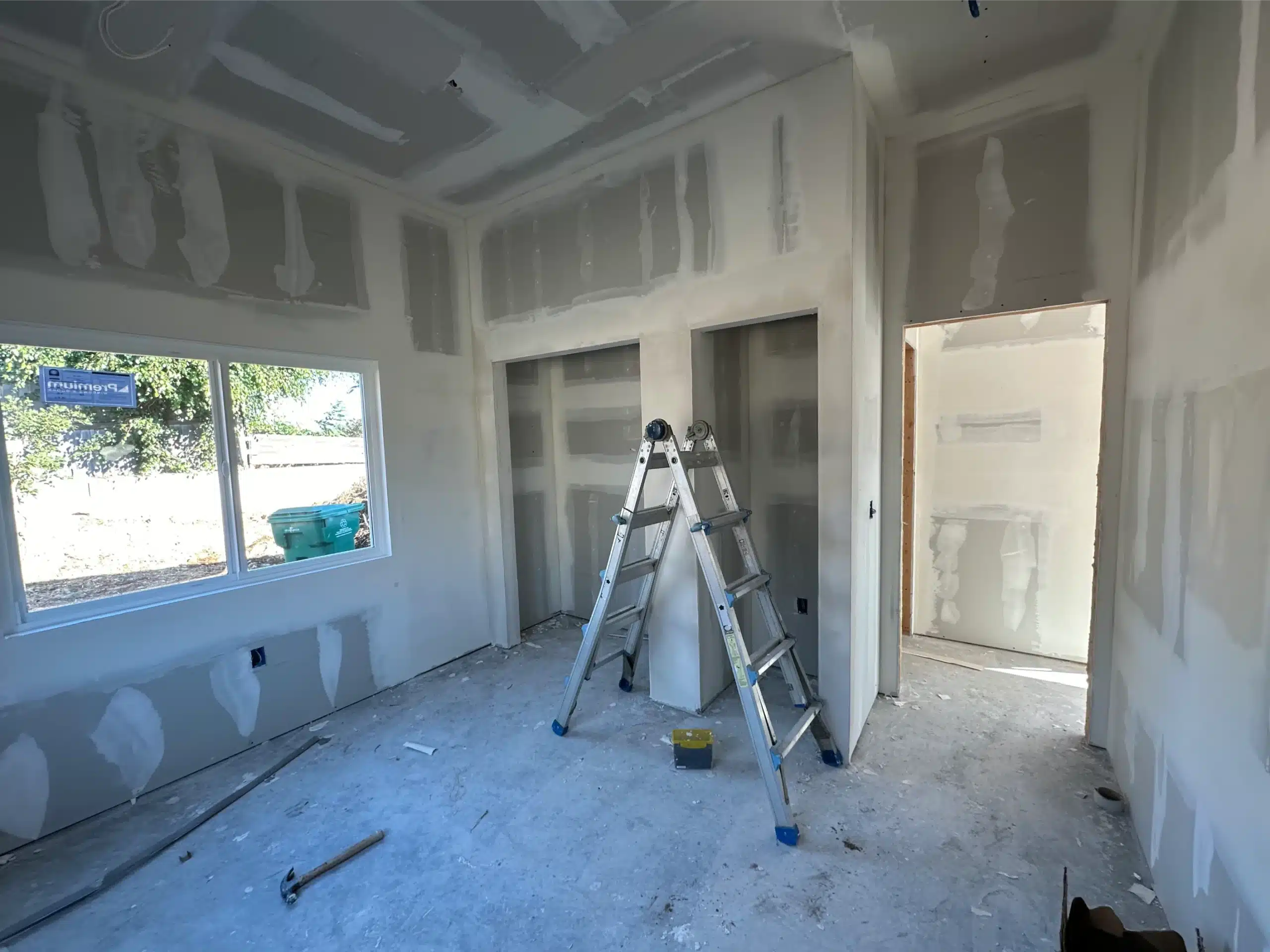 Drywall hung on the ADU walls and ceiling, with a ladder in the main room