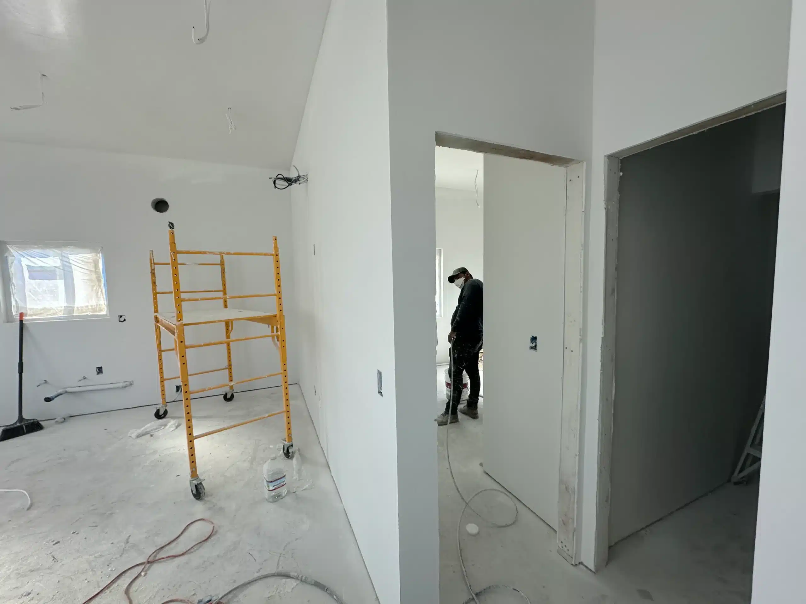 ADU interior taped and finished, with doorways cased and scaffolding in place